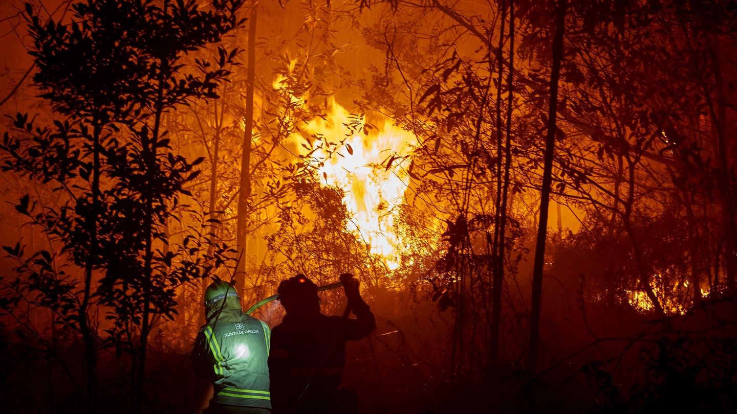 Personal de las brigadas contra el fuego trabajan en la costa de Lugo para evitar un fuego que afecta a varias hectáreas de bosque, sobre todo eucalipto (EFE)