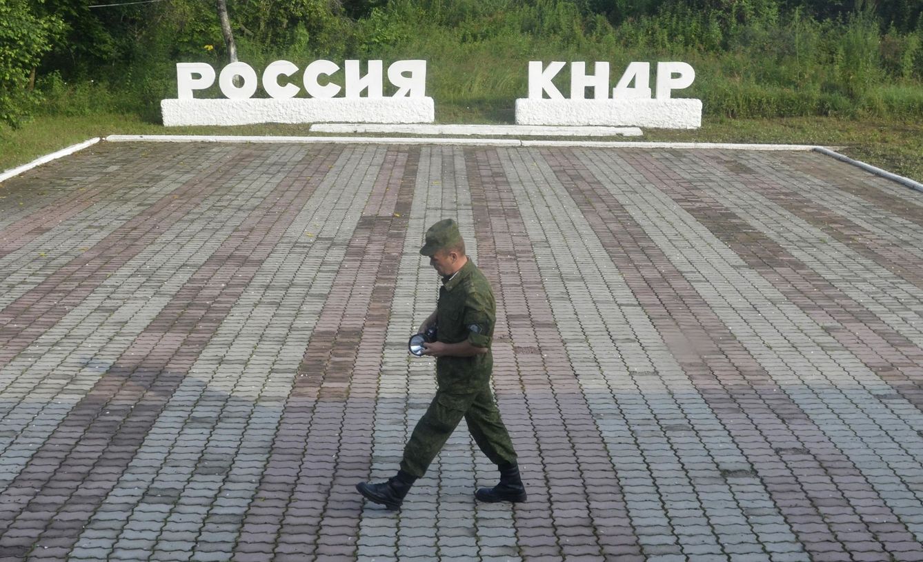 Un guardia pasa frente a dos carteles donde se lee 'Rusia' y 'RDPC', en el paso fronterizo de Tumangang entre Rusia y Corea del Norte. (Reuters)