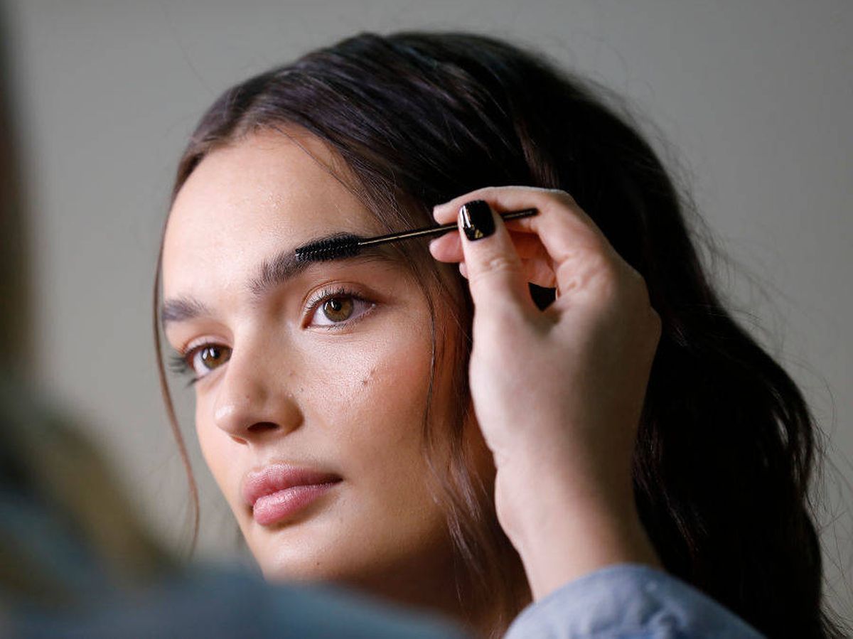 Foto: Maquilladora diseñando las cejas de una modelo en la Australian Fashion Week 2021. (Getty)