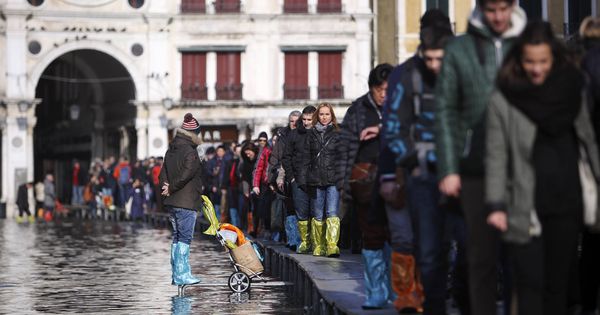 Foto: Turistas caminan en fila por plataformas en la plaza de San Marcos de Venecia. (Reuters)