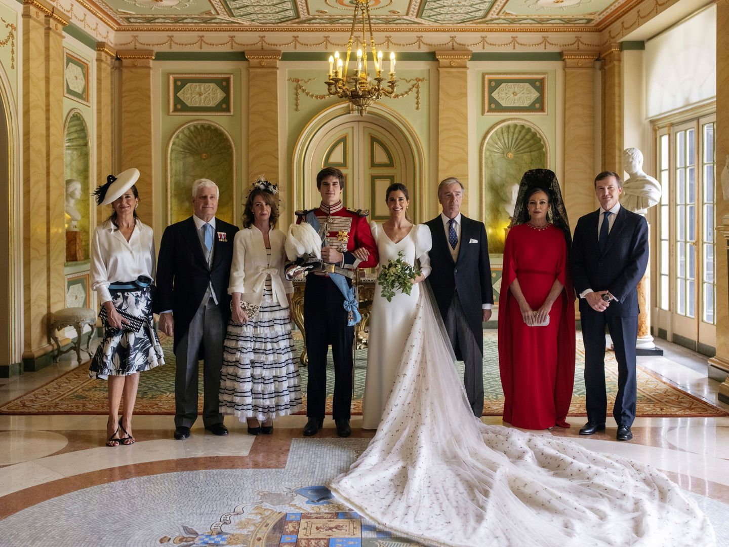 Las dos familias, en la entrada del palacio de Liria. Se puede observar la gran cola que llevaba el vestido. (Alejandra Ortiz/EFE)