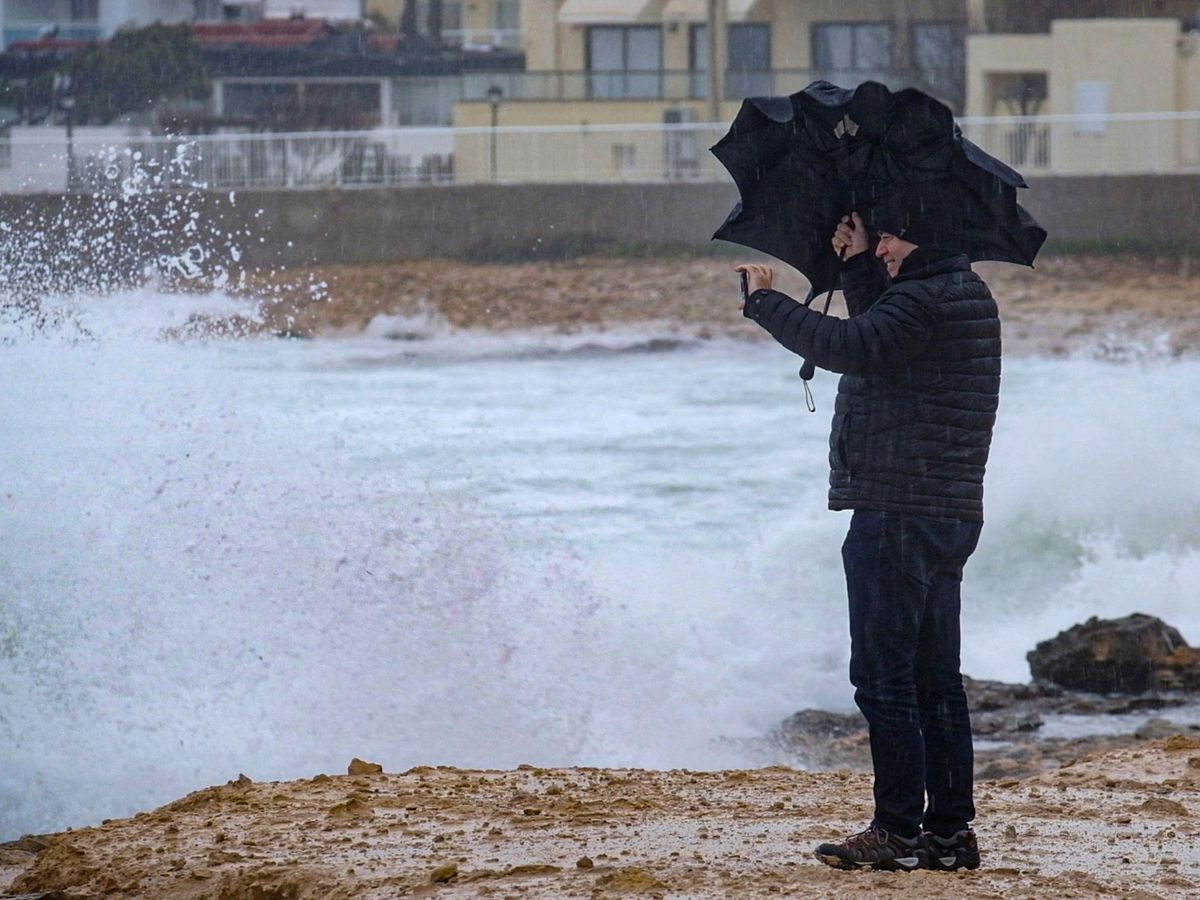 Foto: Un hombre fotografía la costa de Ibiza (EFE)
