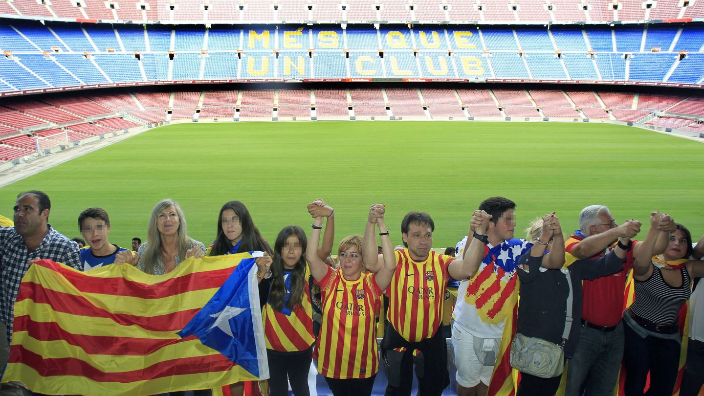 Varias personas participan en la cadena por la independencia a su paso por el Camp Nou. (EFE)