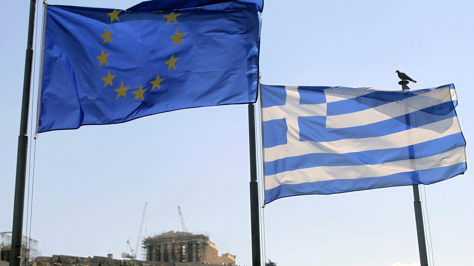 Foto: Una bandera griega y una de la Unión Europea ondean junto a la Acrópolis de Atenas. (EFE)