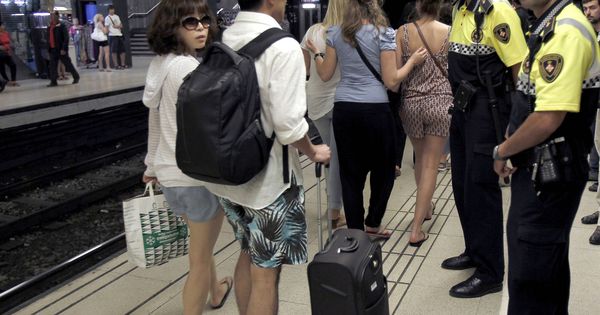 Foto: Dos agentes de la Guardia Urbana informan a los turistas de la presencia de carteristas en el metro de Barcelona, en una foto de archivo. (EFE)