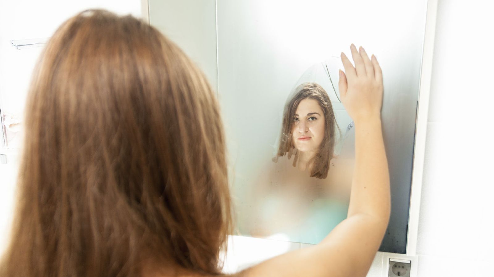 Foto: ¿Será quitar el vaho del espejo con la mano? (iStock)