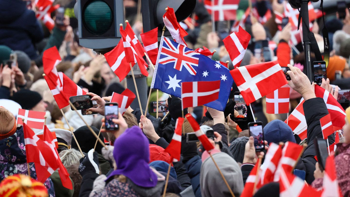 People hold flags as they gather on the day Danish Queen Margrethe abdicates after 52 years on the throne, and her elder son, Crown Prince Frederik, ascends the throne as King Frederik X, in Copenhagen, Denmark, January 14, 2024. REUTERS Wolfgang Rattay