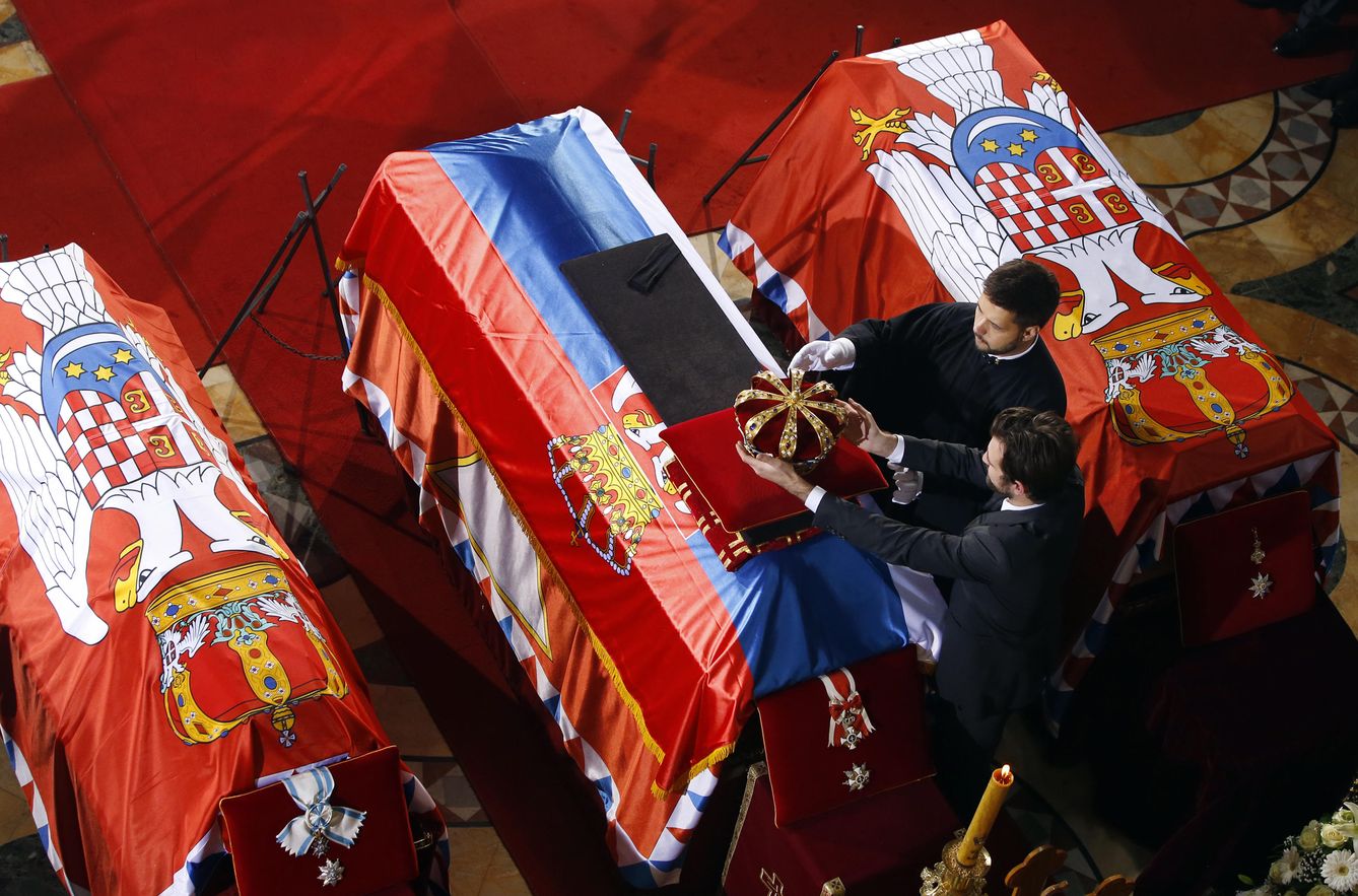 El príncipe Pedro Karadordevic (d) coloca una corona sobre el ataúd de su abuelo, Pedro II, durante el funeral en Topola (Reuters). 