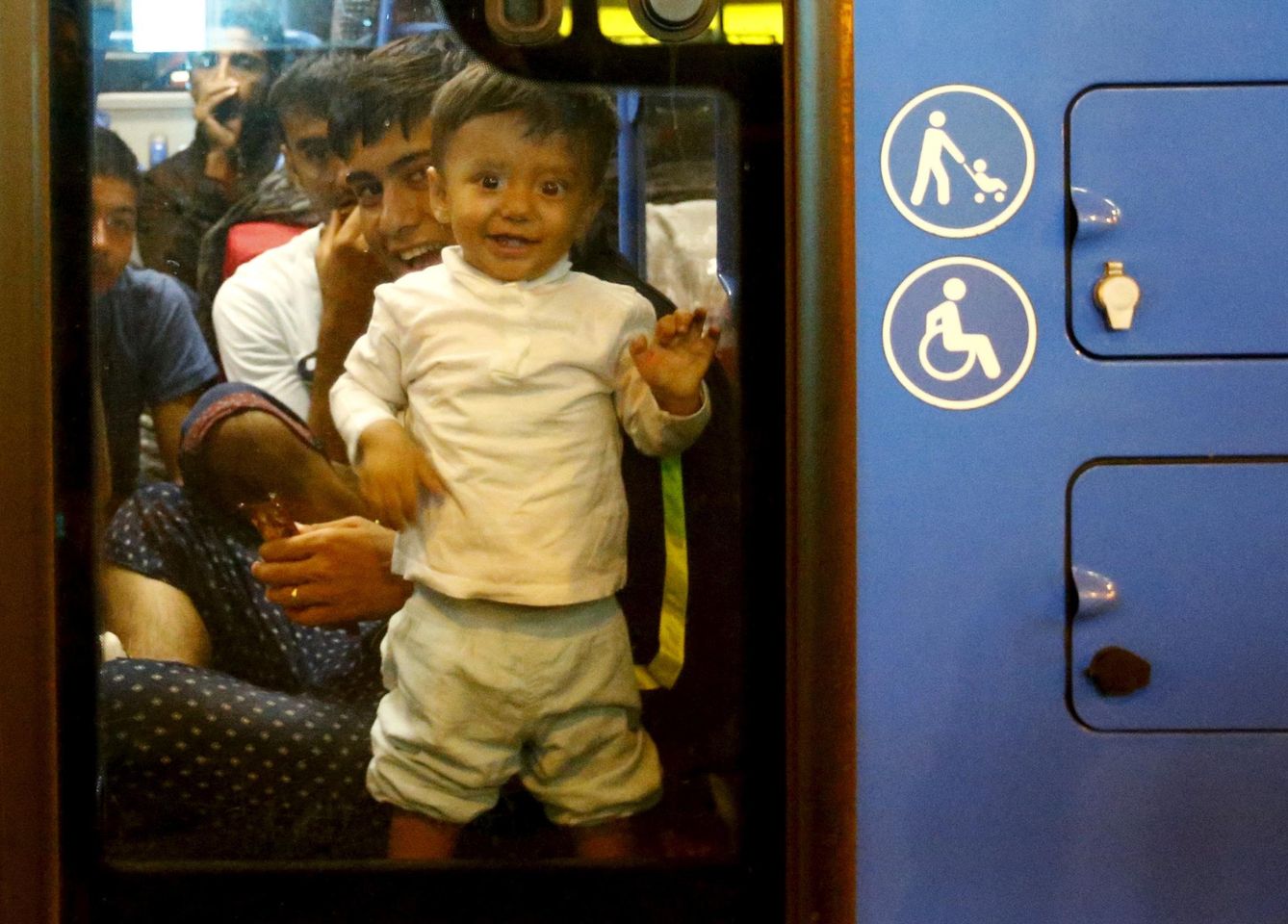 Un niño sirio subido en un autobús con destino a Alemania (Reuters).
