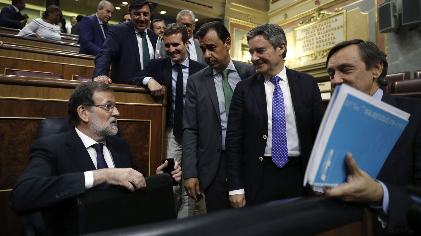 El presidente del Gobierno, Mariano Rajoy (i), conversa con diputados de su grupo en el Congreso. (EFE)