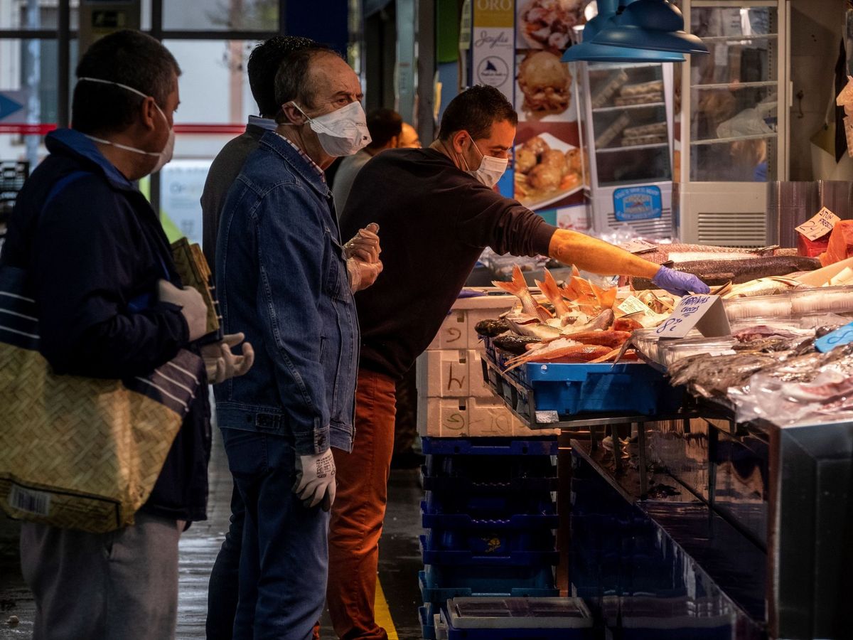 Foto: Varias personas con mascarilla en el Mercado del Carmen de Huelva. (EFE)