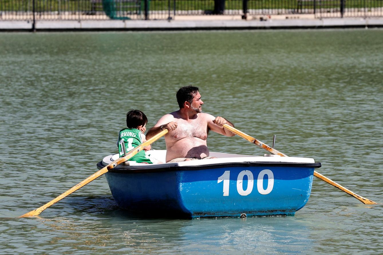 Un padre y un hijo disfrutan de un paseo en barca en el parque del Retiro. (EFE/Chema Moya)
