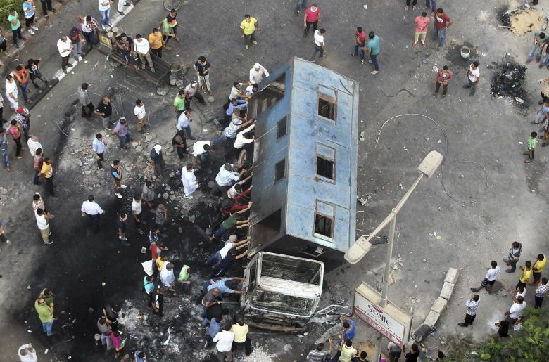 Numerosos simpatizantes del depuesto presidente Mohamed Mursi tratan de volcar un camión. (EFE)