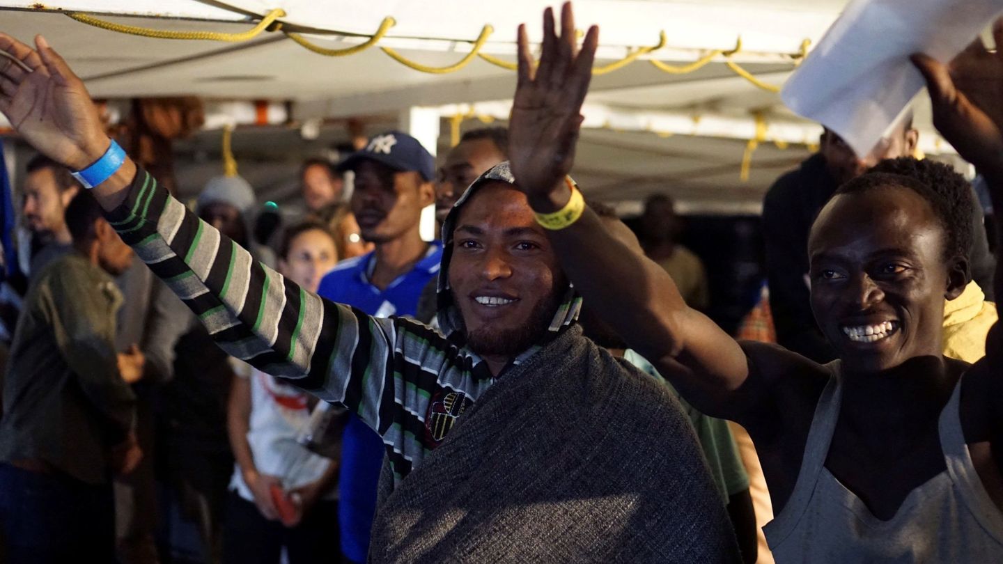 Algunos de los migrantes que quedaban a bordo del barco de la ONG española Open Arms saludan momentos antes de desembarcar. (EFE)