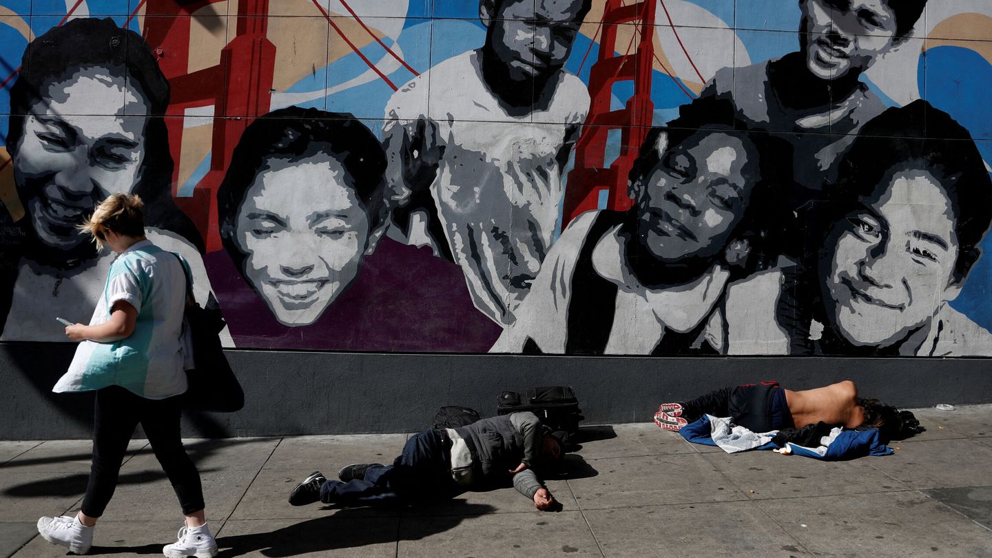 Una mujer camina por las calles del barrio de Tenderloin, en San Francisco, entre varios 'sin techo' tendidos sobre la acera. (Reuters/Shannon Stapleton)