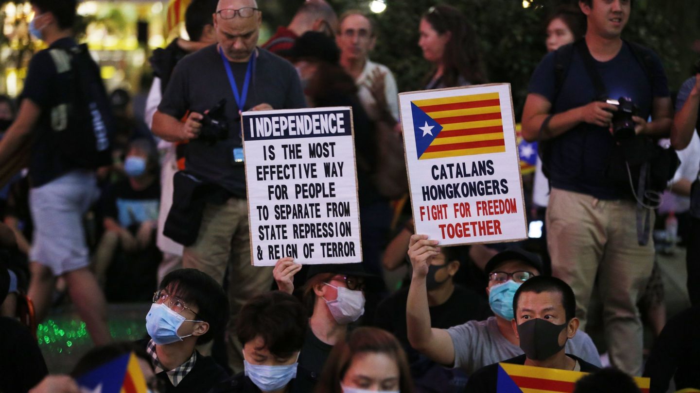 Varios manifestantes de Hong Kong muestran carteles a favor de la independencia en Cataluña. (Reuters)