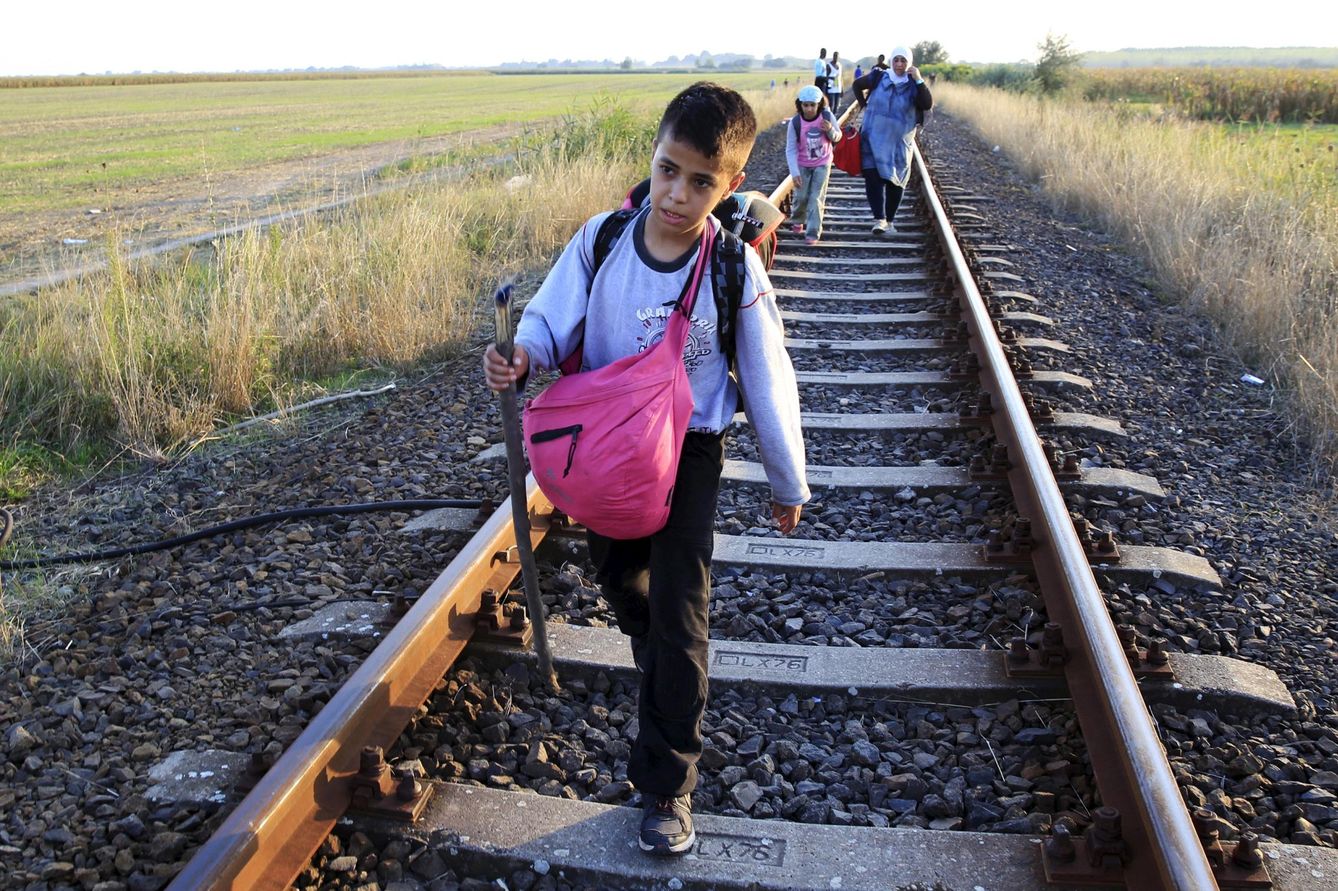 Un niño camina por una vía de tren tras cruzar la frontera húngara cerca de Roszke (Reuters).