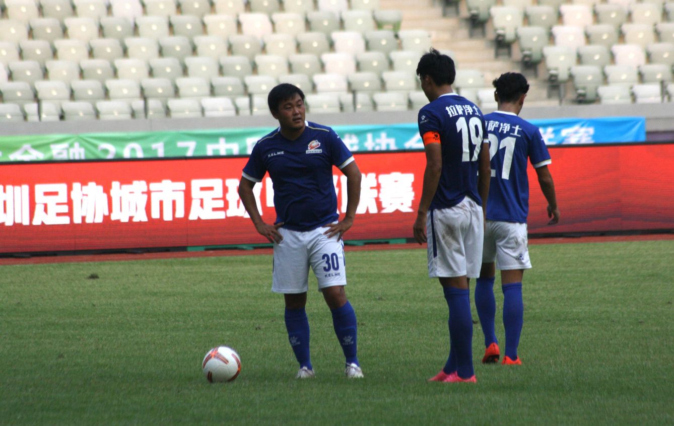 Varios jugadores del Lhasa FC hablan antes del lanzamiento de un penalti, durante un partido en Shenzen, el pasado septiembre. (J. Ibáñez)