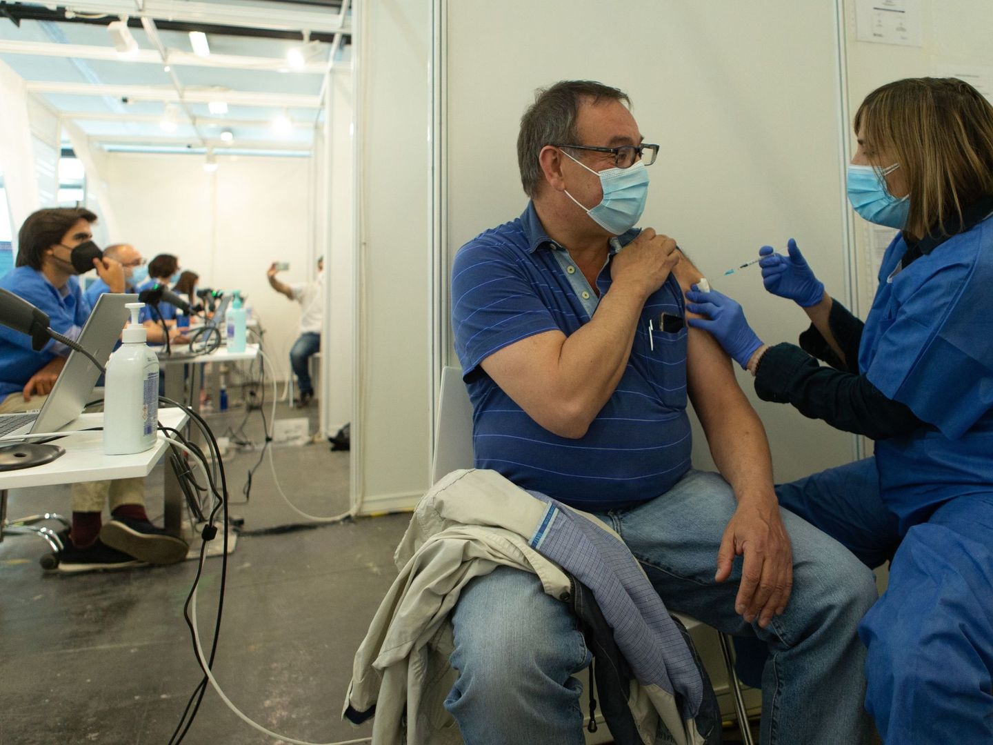 Una enfermera vacuna a un hombre en el centro de vacunación de la Fira de Barcelona. (EFE)