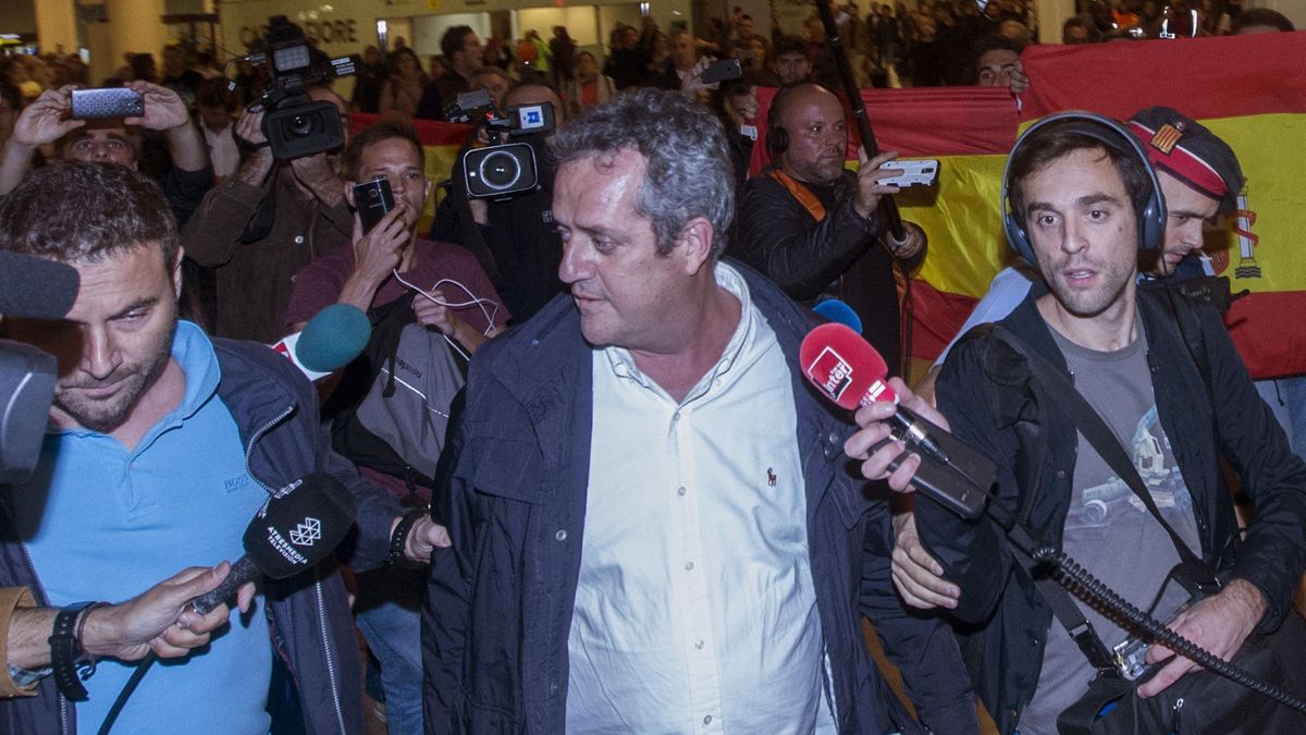Dos 'exconsellers' son recibidos en El Prat con abucheos y banderas españolas