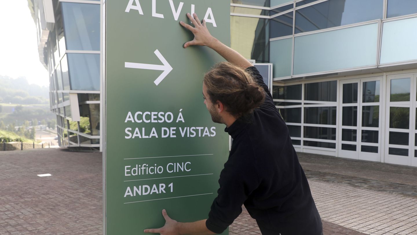 Un trabajador de los juzgados de Santiago coloca una cartel para indicar la sala de la vista del juicio del accidente del Alvia. (EFE/Xoán Rey)