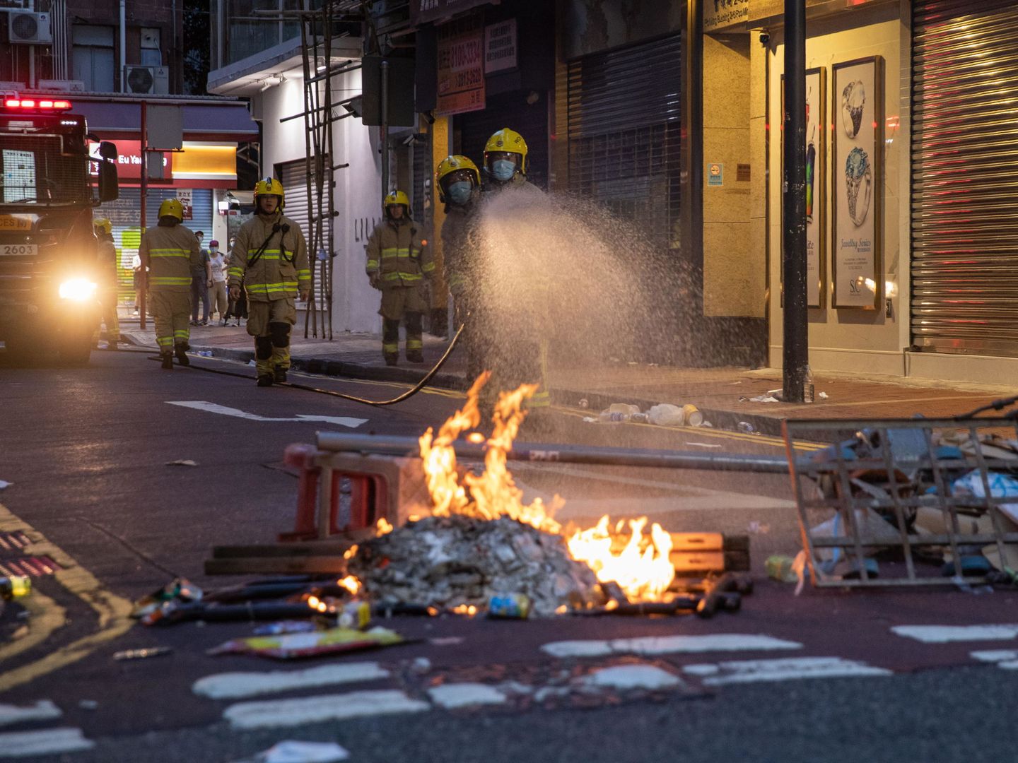 Los bomberos sofocan una pequeña barricada tras las protestas de hoy en Hong Kong. (EFE)
