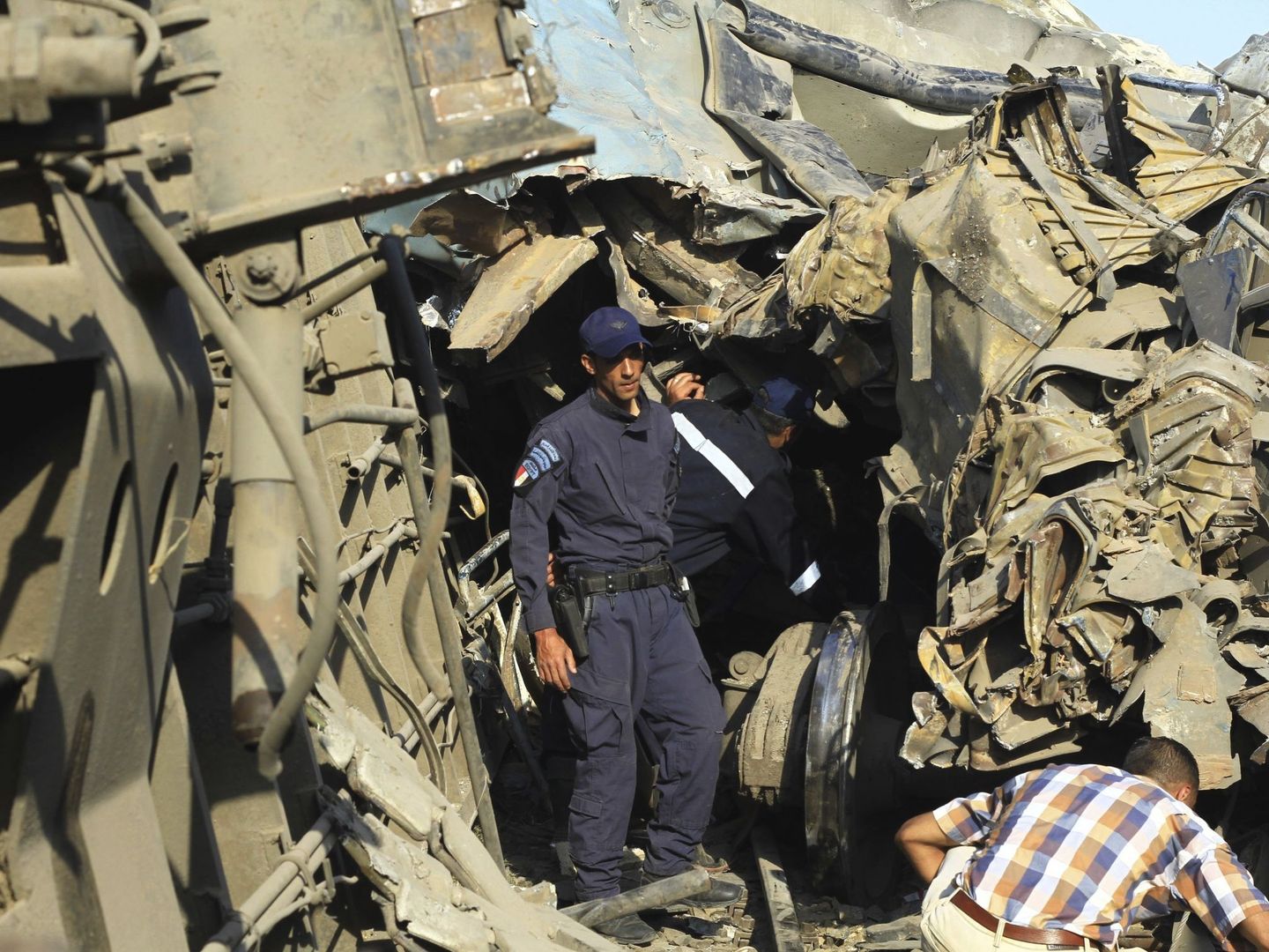 Un oficial de seguridad examina los restos tras el choque de trenes a las afueras de Alejandría. (EFE)