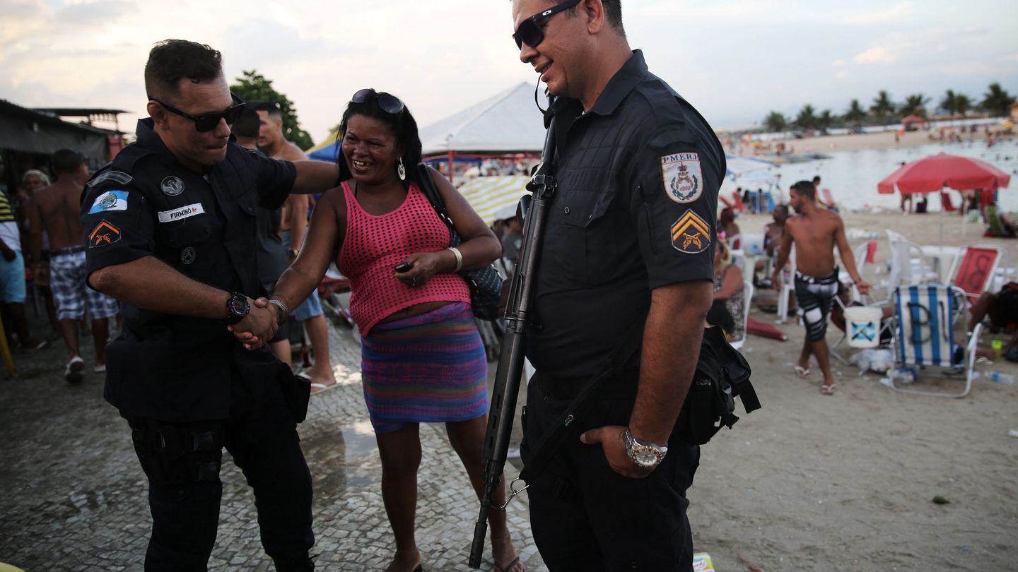 Una mujer bromea con un agente en una piscina artificial en el norte de Río, en enero de 2017. (Reuters)