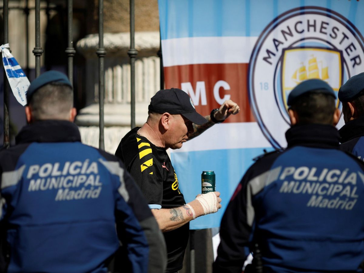 Foto: - Un aficionado del Manchester City junto a varios efectivos de la Policía Municipal. (EFE/David Fernández)
