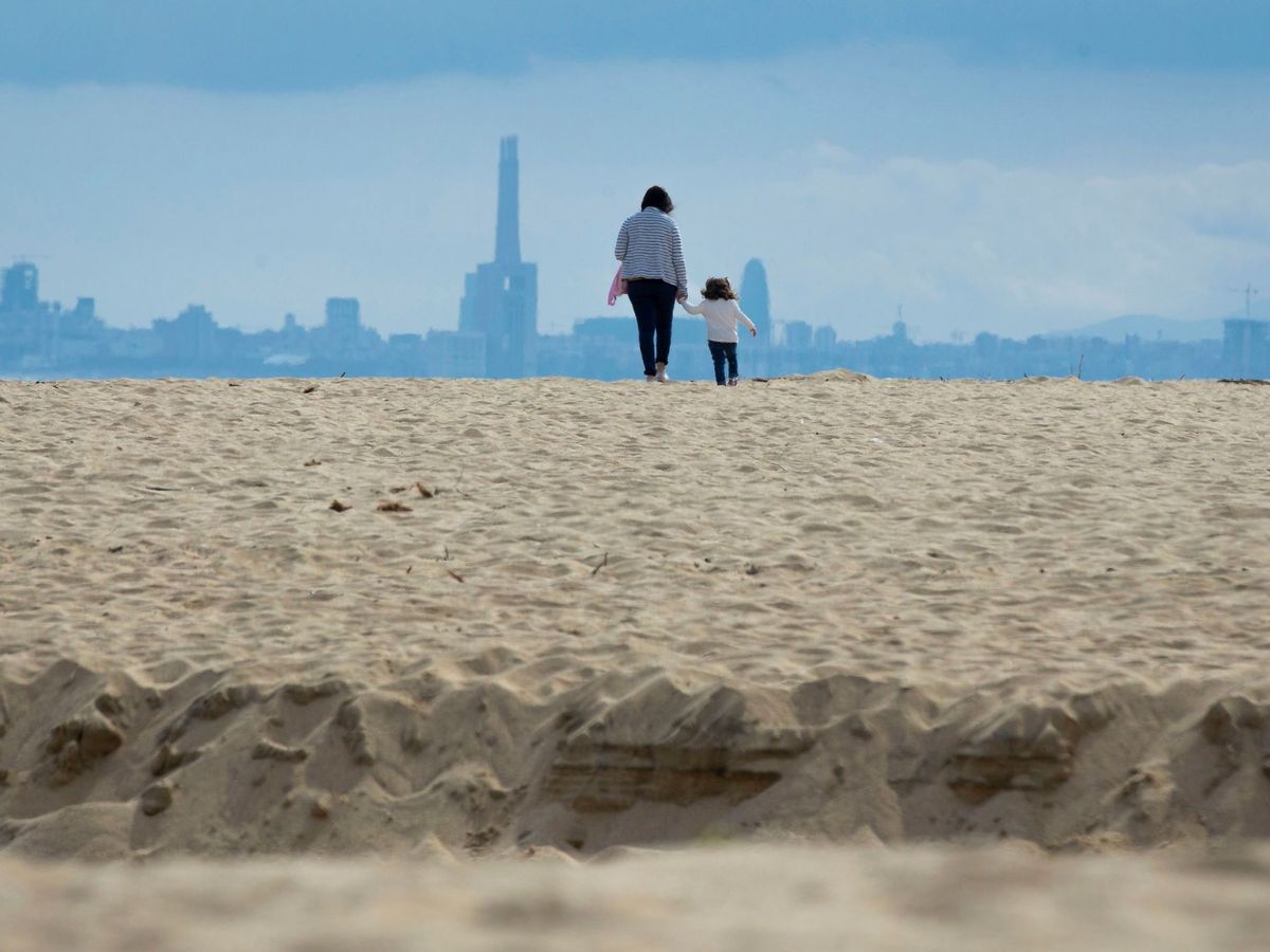 Foto: Una madre y su hija juegan y pasean en la playa de El Masnou. (EFE)