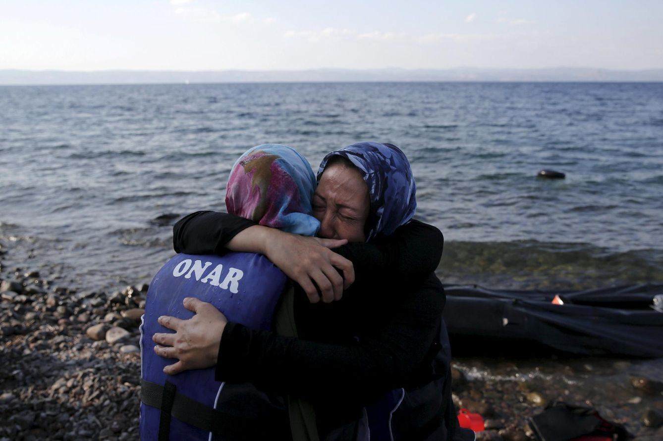 Dos afganas se abrazan momentos después de alcanzar la isla griega de Lesbos, cercana a Turquía (Reuters).