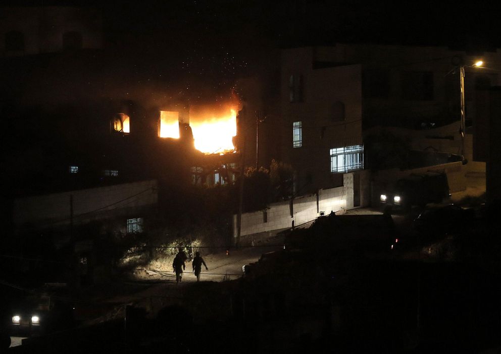 Foto: Soldados israelíes caminan ante las llamas de la casa familiar en Hebrón de un palestino acusado del secuestro de los jóvenes israelíes (Reuters).