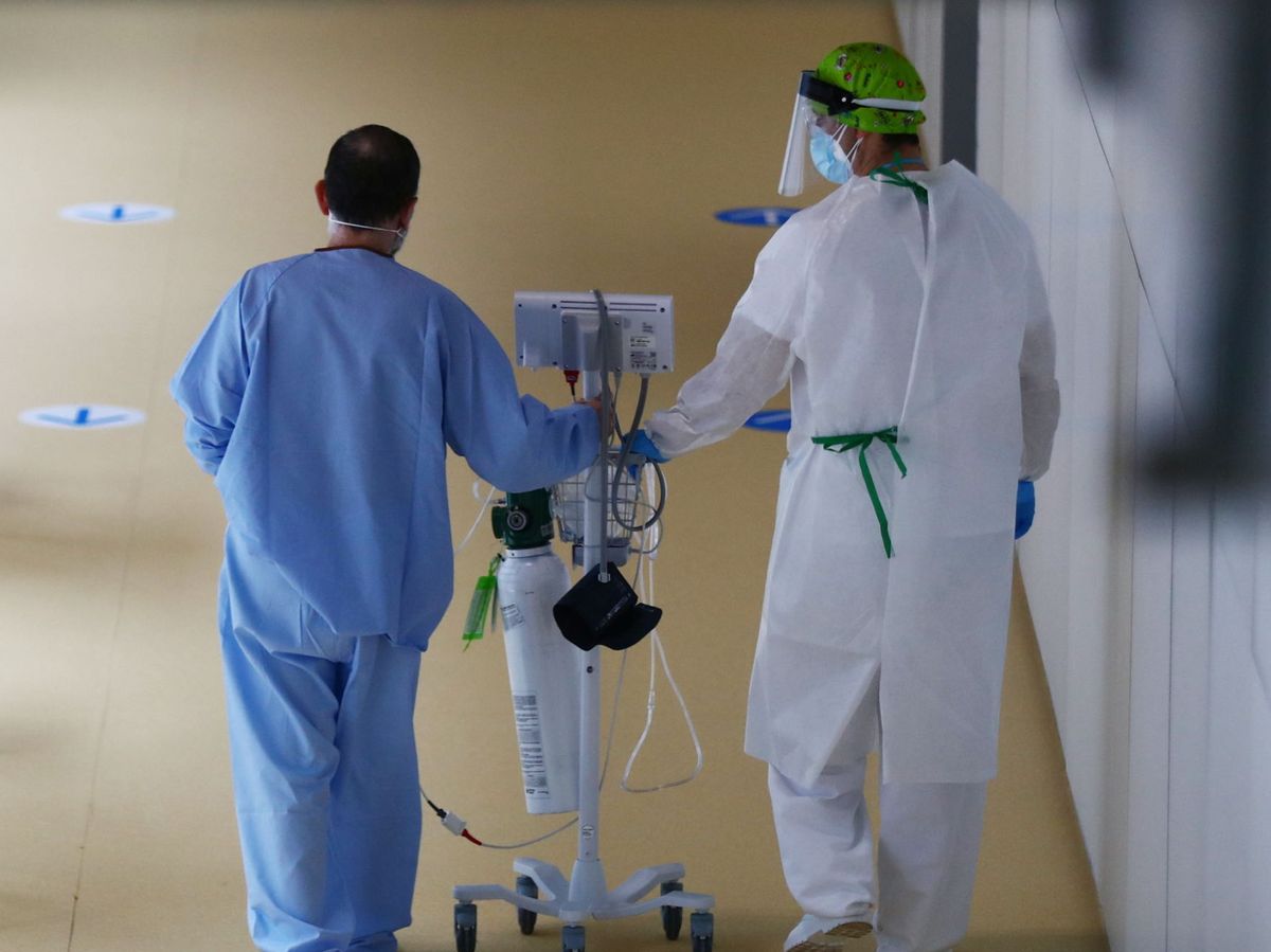 Foto: Una enfermera camina junto a un enfermo de covid-19. (Reuters) 