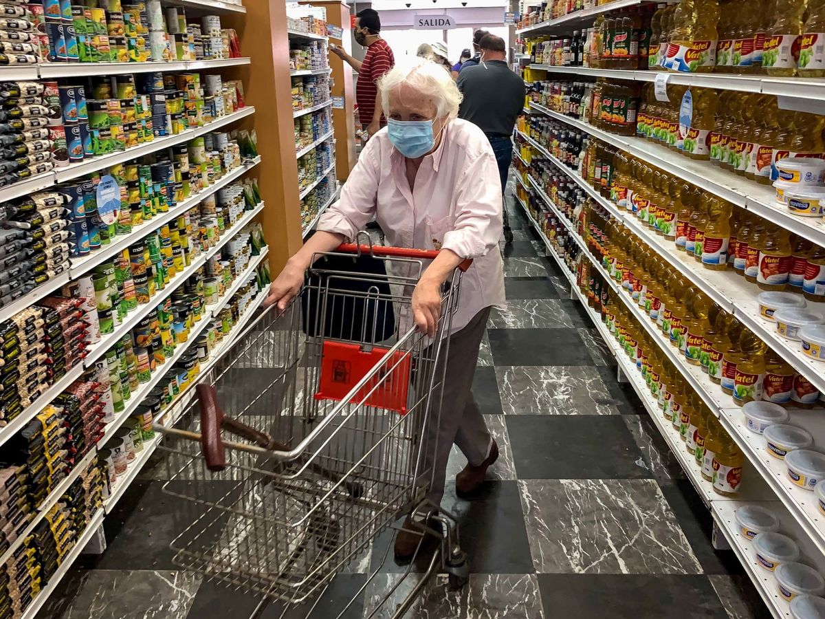 Foto: Un grupo de personas revisa precios de productos en un supermercado. (EFE)
