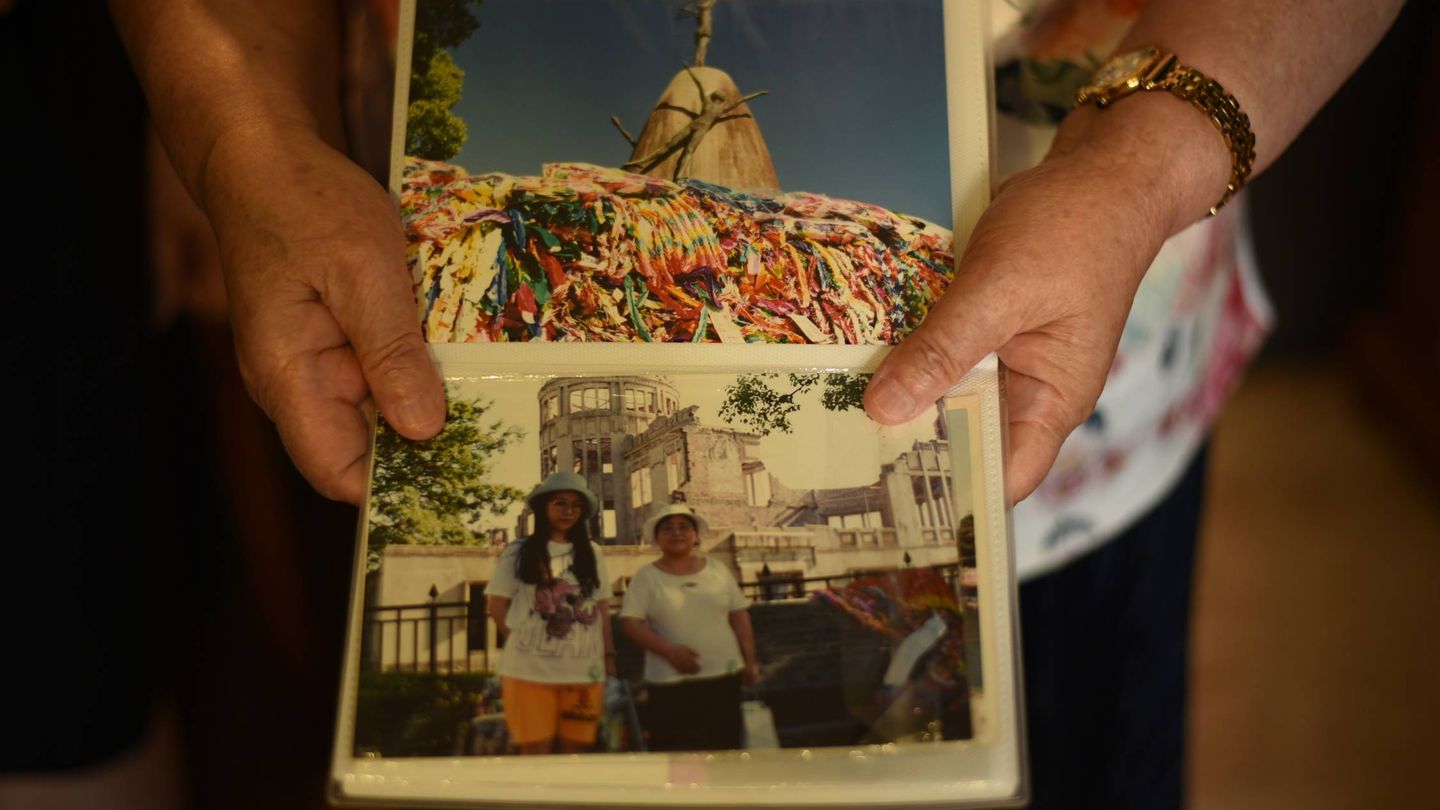 Las manos de Takako muestran fotografías de un viaje a Hiroshima. (Toñi Guerrero)