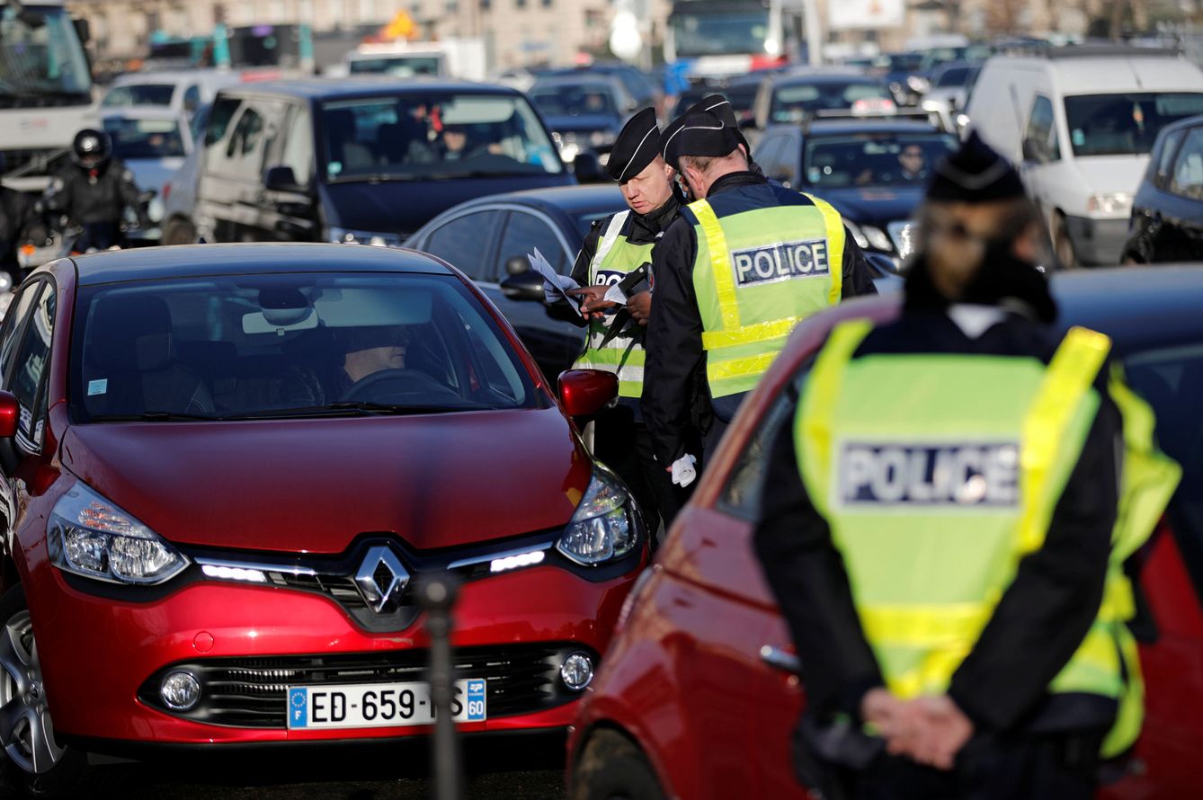 Policías registran los papeles de vehículos debido a la prohibición de circular en días alternos, en París, el 6 de diciembre de 2016 (Reuters)