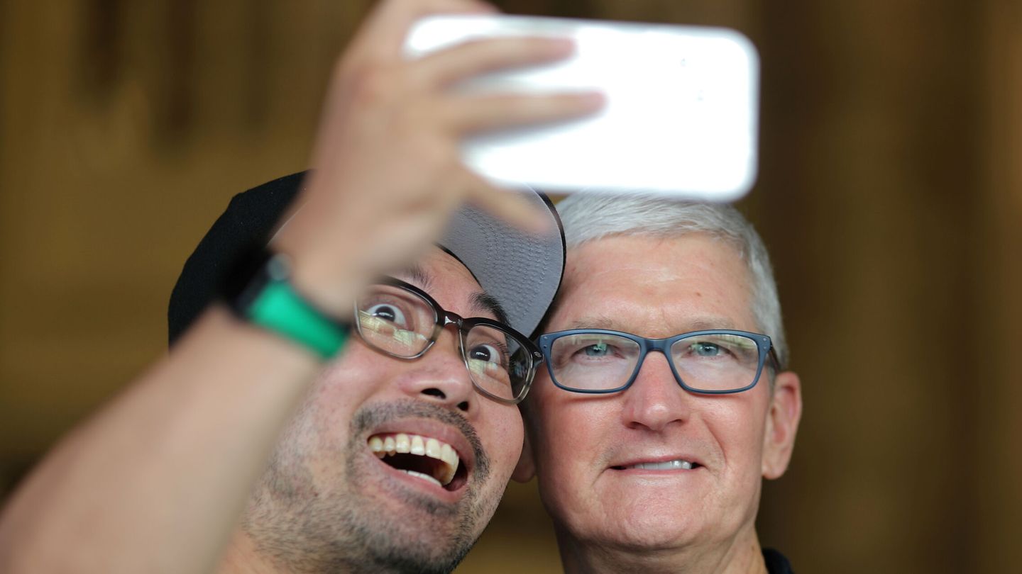 Tim Cook (derecha), CEO de Apple, se fotografía con un empleado de la compañía. (Reuters)
