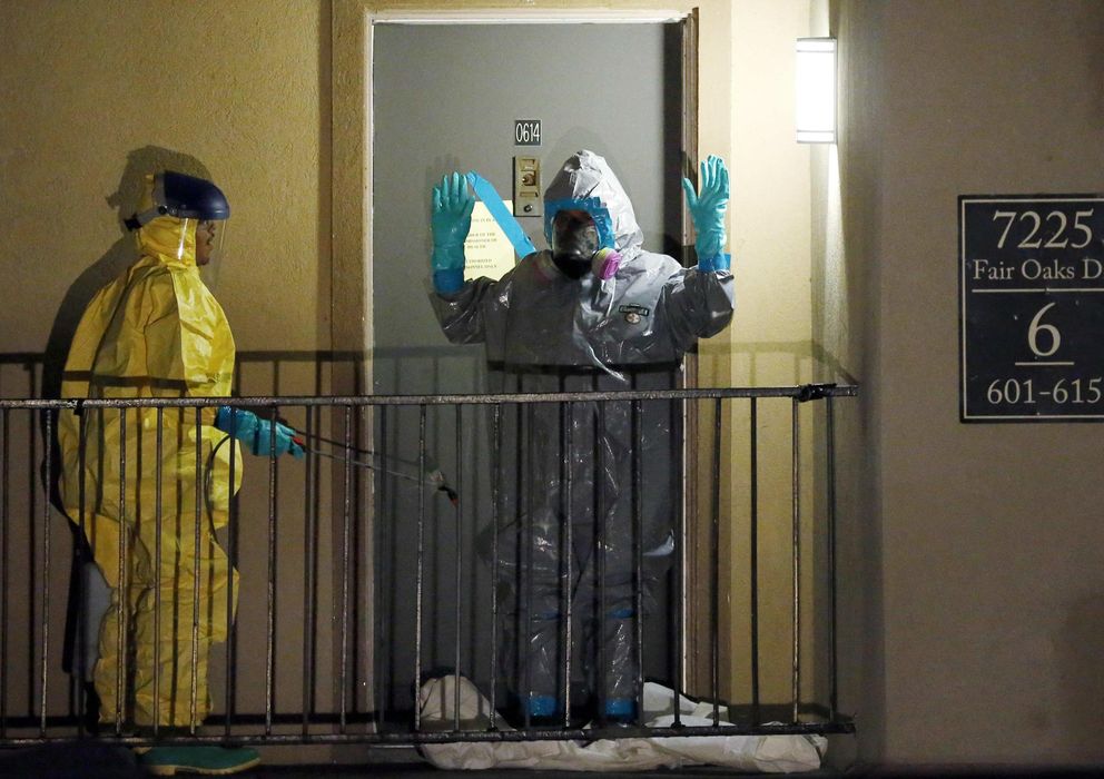 Foto: Dos trabajadores sanitarios abandonan el apartamento del hombre diagnosticado con ébola en Dallas. (Reuters)
