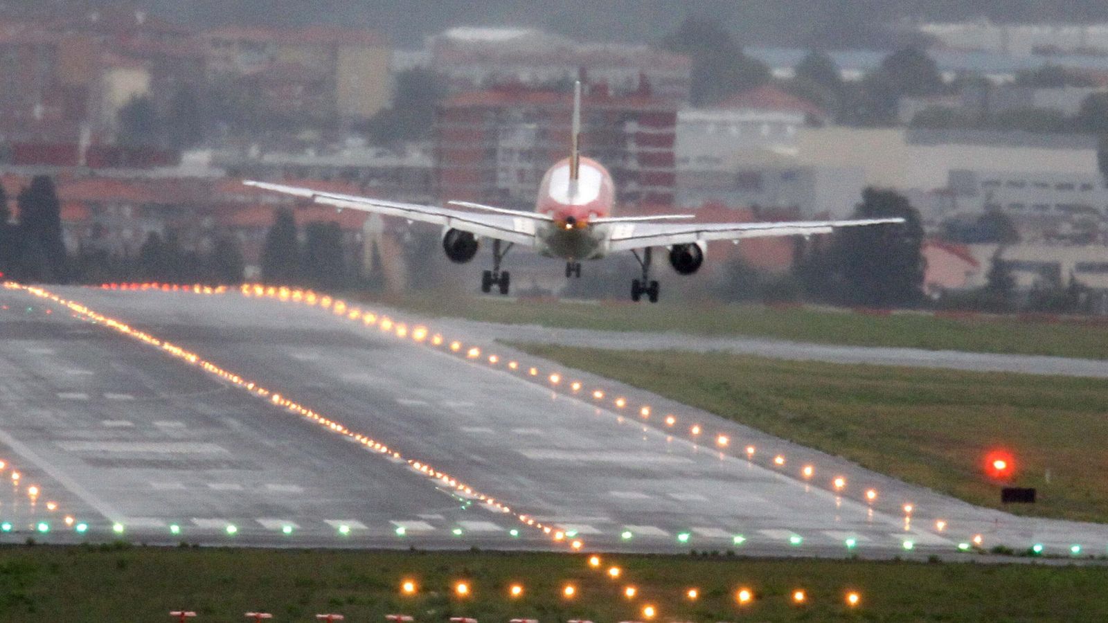 Foto: Las rachas de viento cruzan un avión en el momento de tomar tierra en el aeropuerto de Bilbao, en la localidad de Loiu. (EFE)