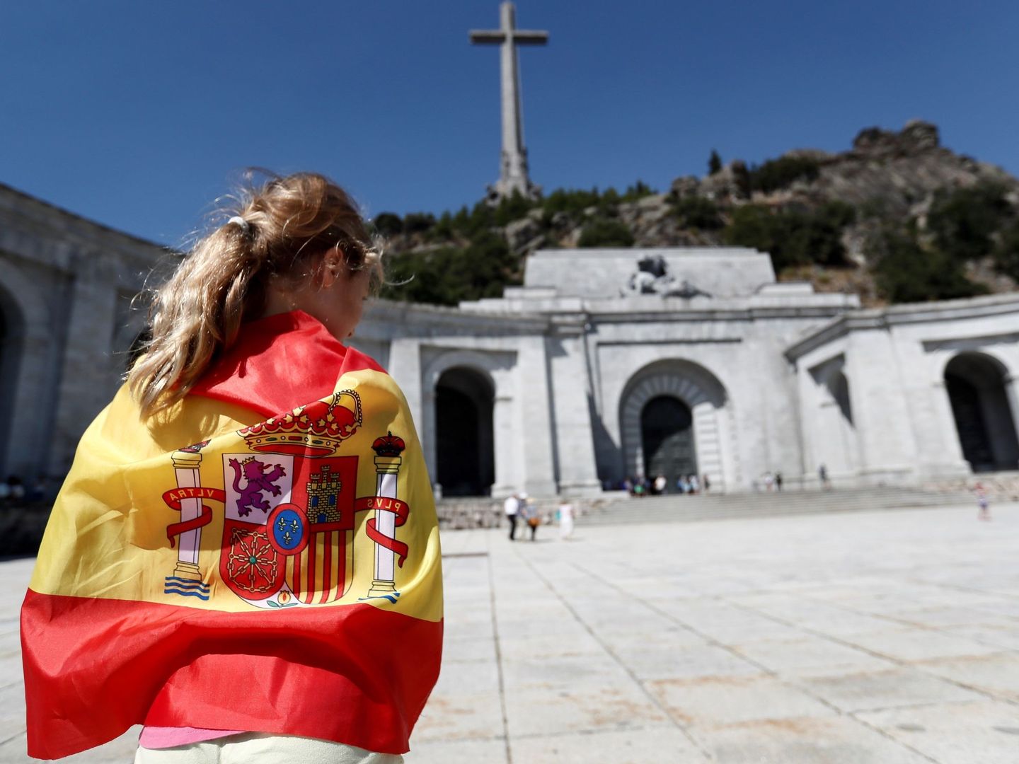Una persona envuelta en una bandera en la explanada del Valle de los Caídos. (EFE/Mariscal)