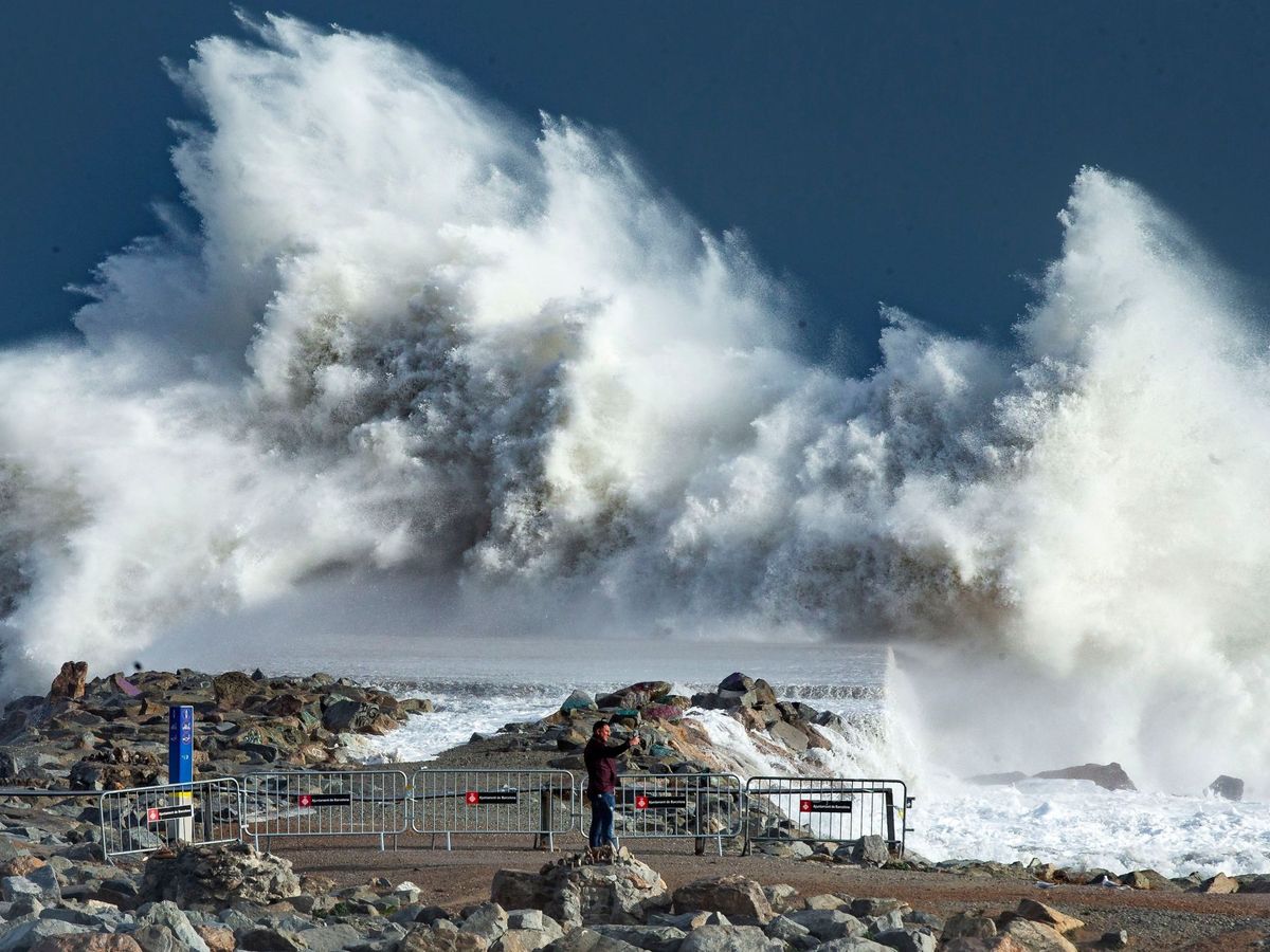 Foto: Una gigantesca ola en la playa de la Barceloneta. (EFE)