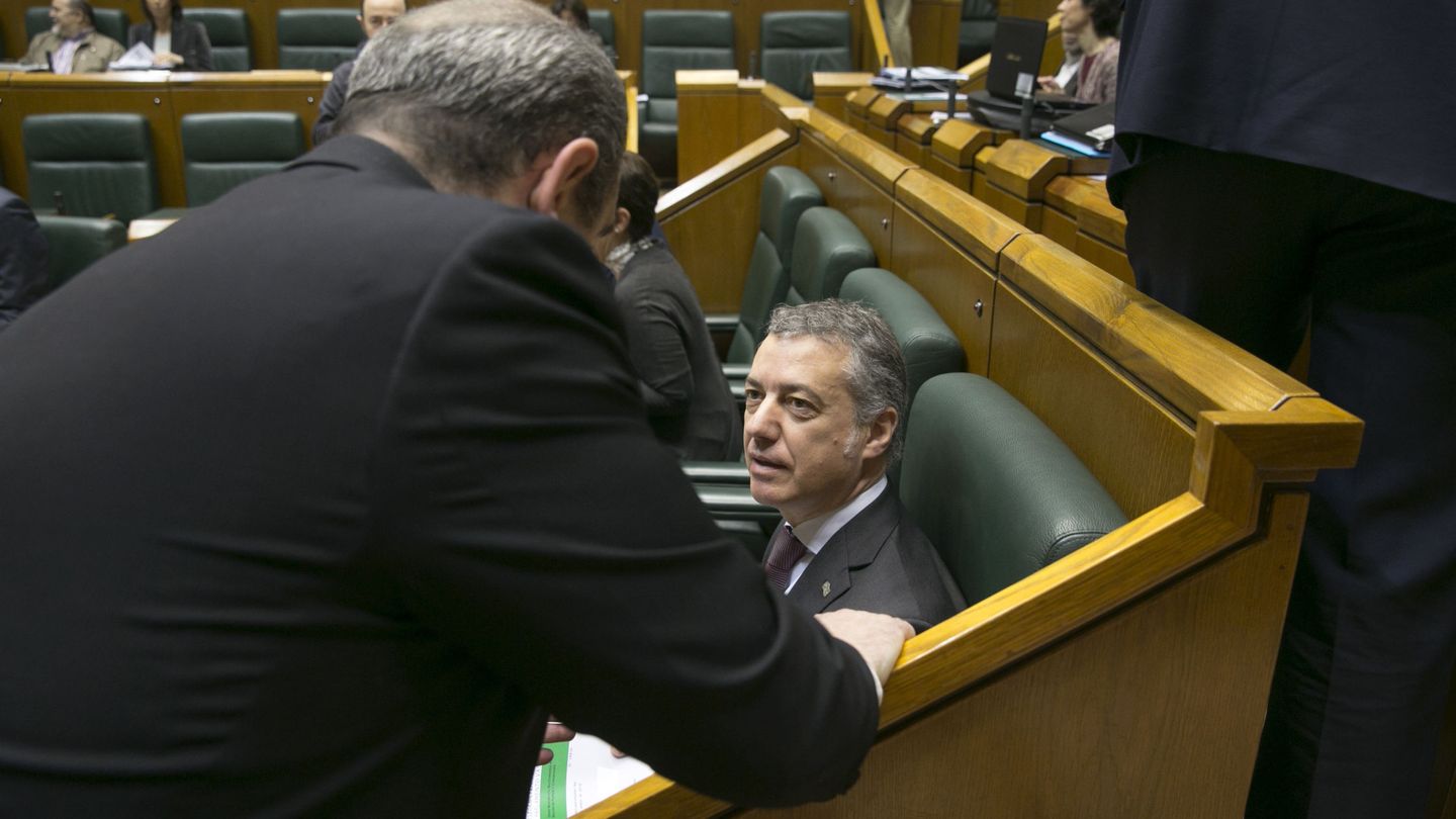 Iñigo Urkullu conversa con un compañero de grupo al comienzo del pleno de control en el Parlamento vasco. (EFE)