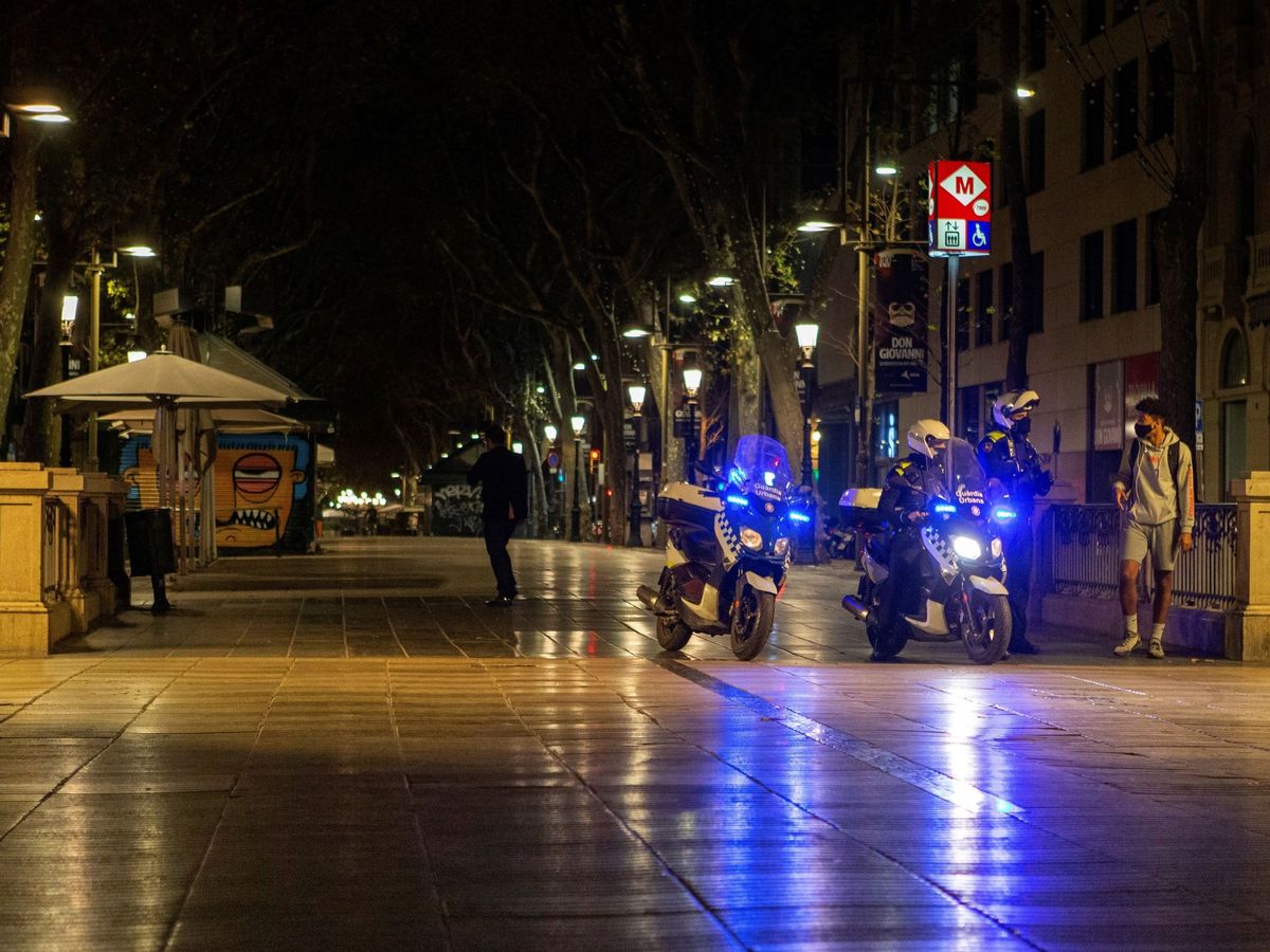 Foto: La Guardia Urbana informa del toque de queda a transeúntes en Barcelona. (EFE)