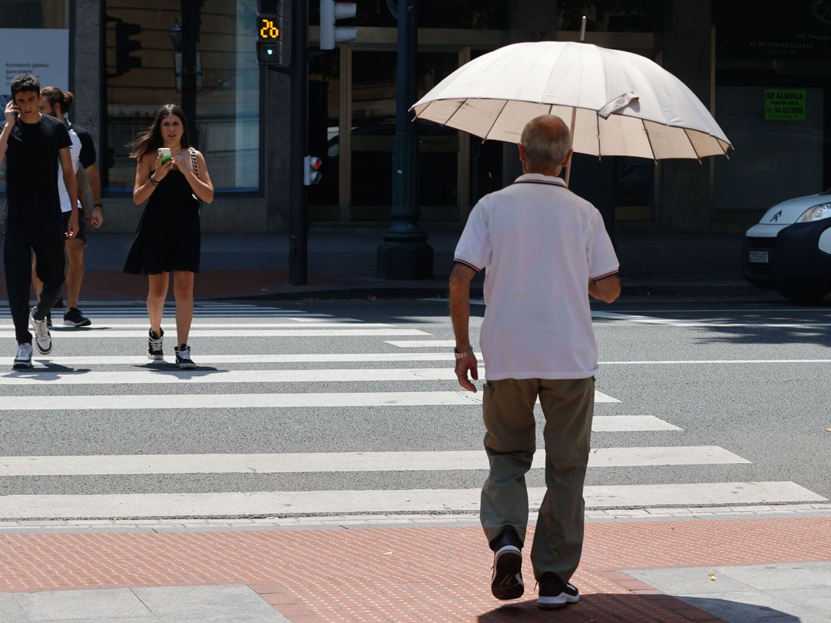 Foto: Un hombre se protege del sol este lunes en Bilbao, como consecuencia de la ola de calor.  (EFE/Luis Tejido)