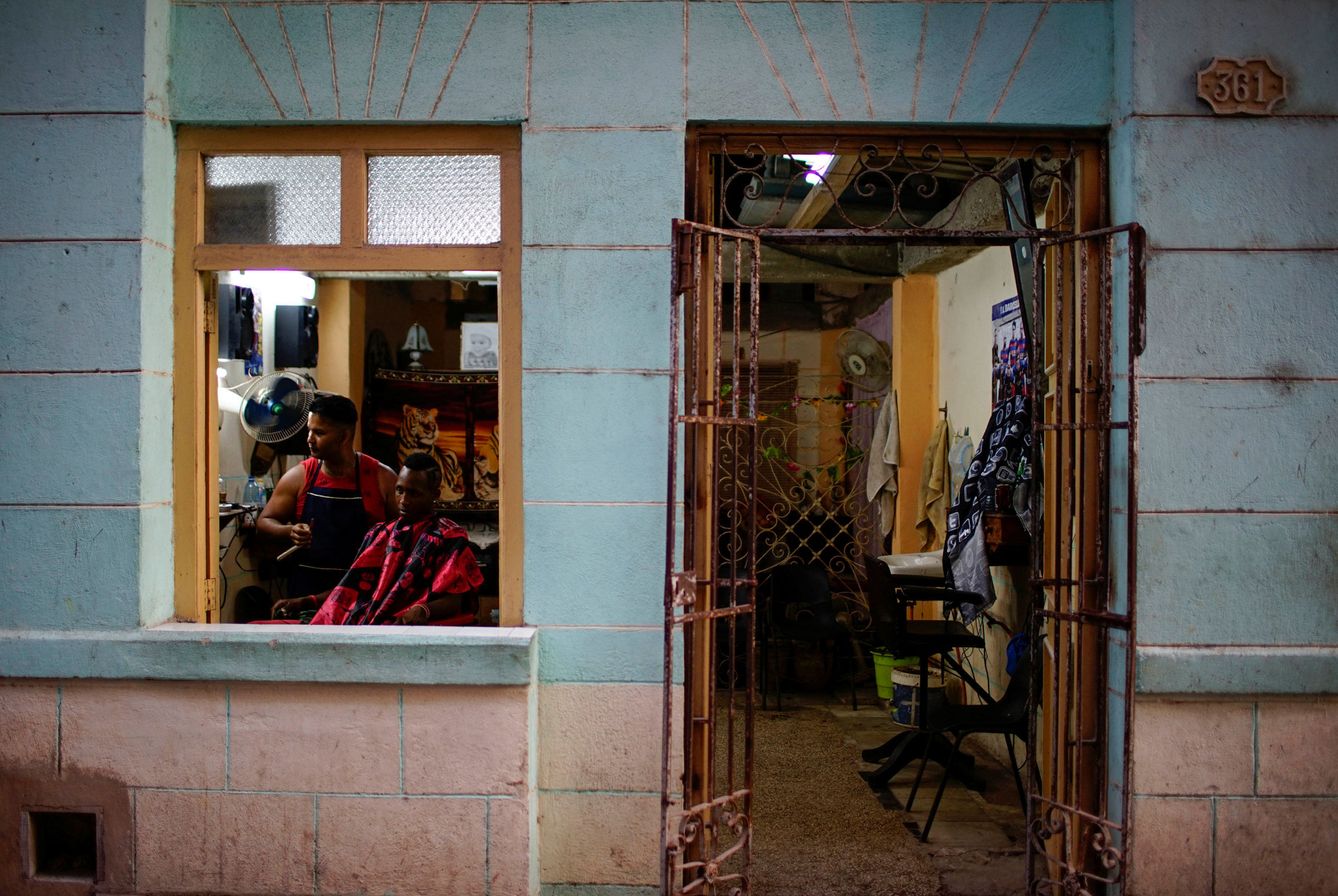 Un conductor de bicitaxi se corta el pelo en una barbería privada en La Habana, el 1 de agosto de 2017. (Reuters)