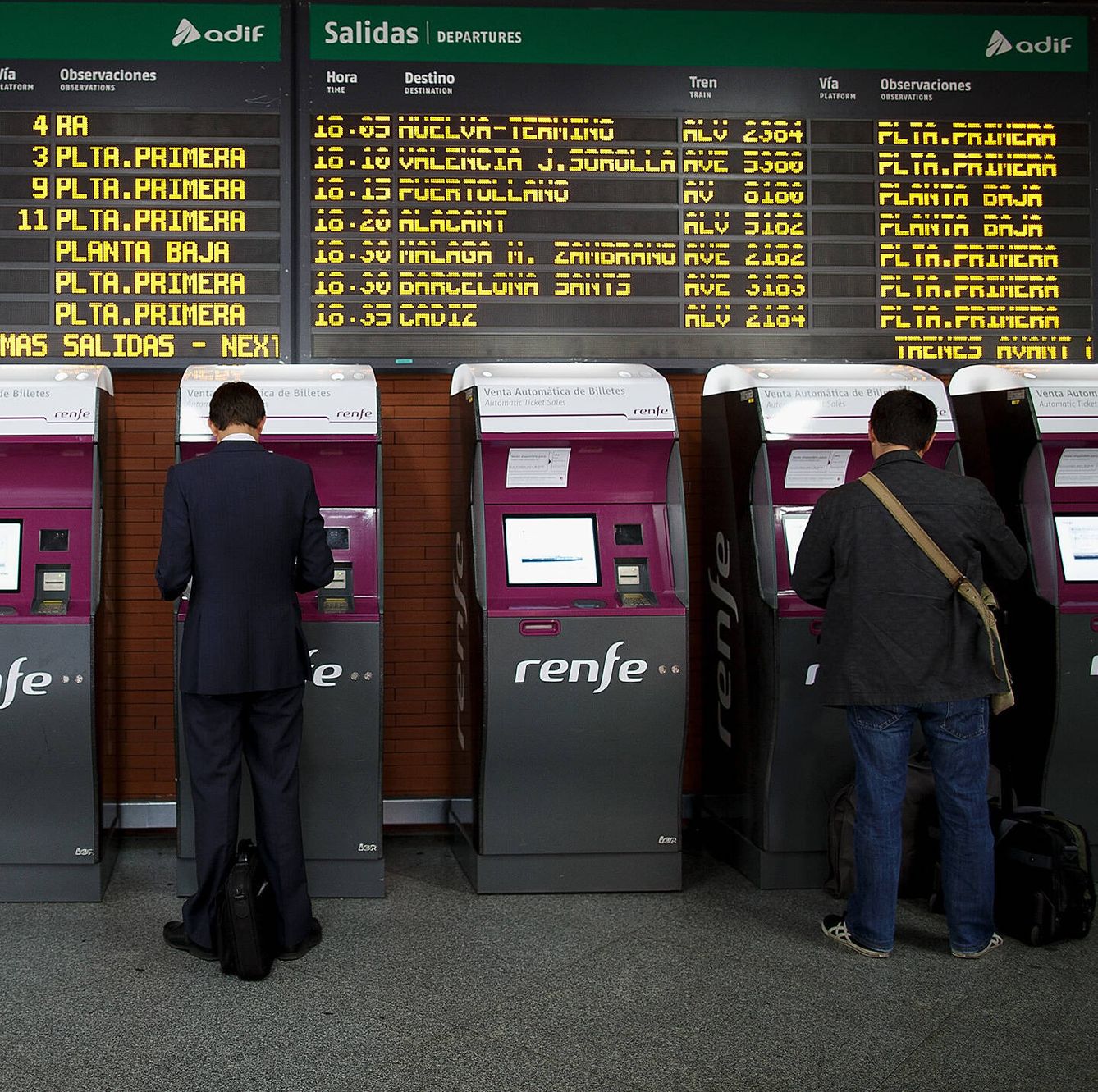 Dos hombres gestionan sus billetes de tren en la estación de Atocha. (Getty/Pablo Blázquez Dominguez)