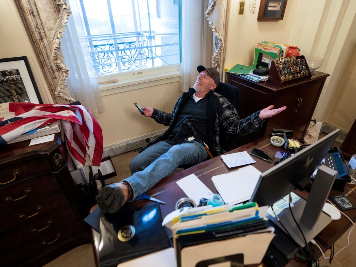 Foto: Un seguidor de Donald Trump se sienta en el escritorio de la presidenta de la Cámara de Representantes de Estados Unidos, Nancy Pelosi. (EFE) 