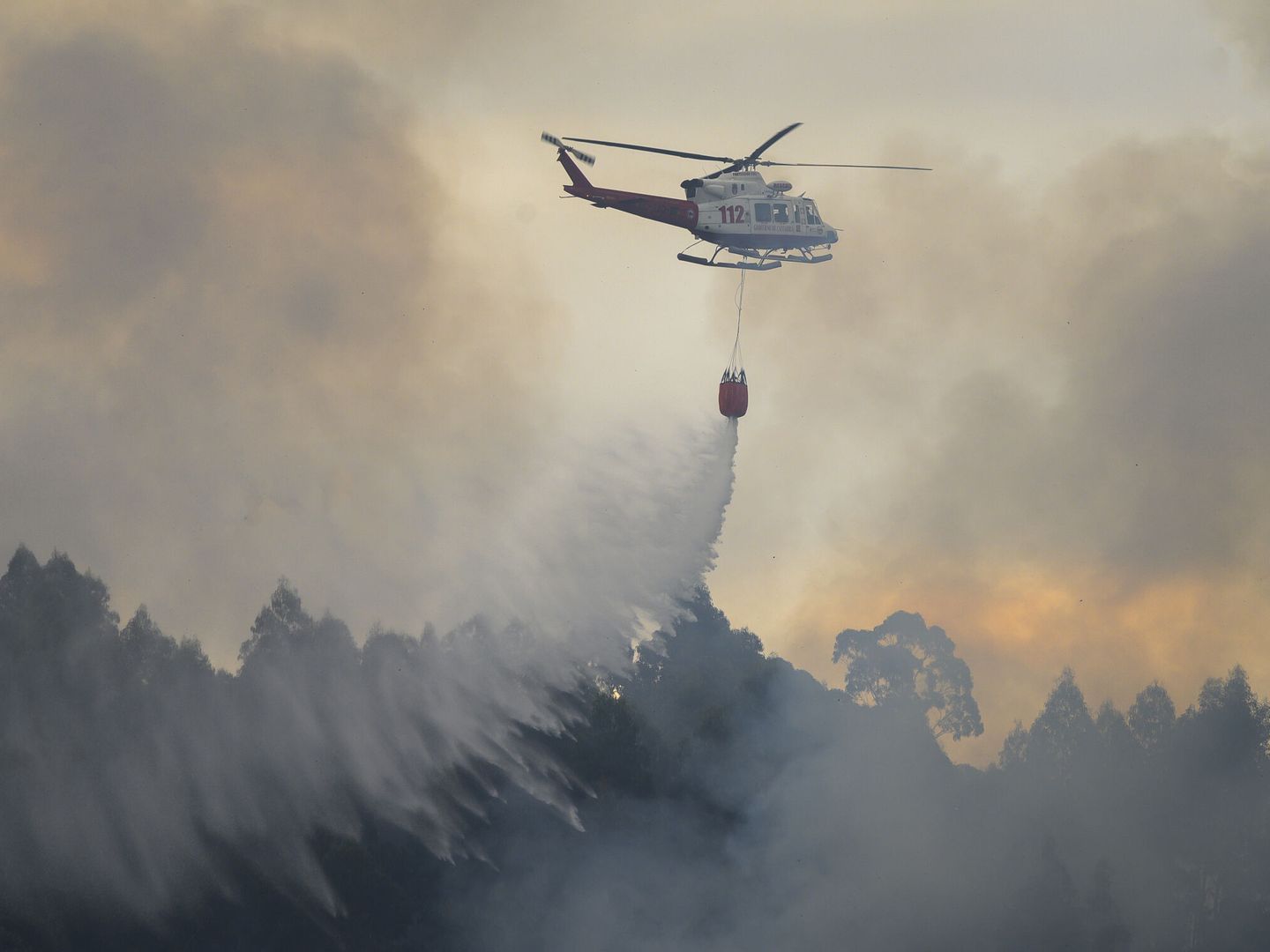 El helicóptero del 112 del Gobierno de Cantabria, durante los trabajos de extinción del incendio forestal de Hazas de Cesto. (EFE)