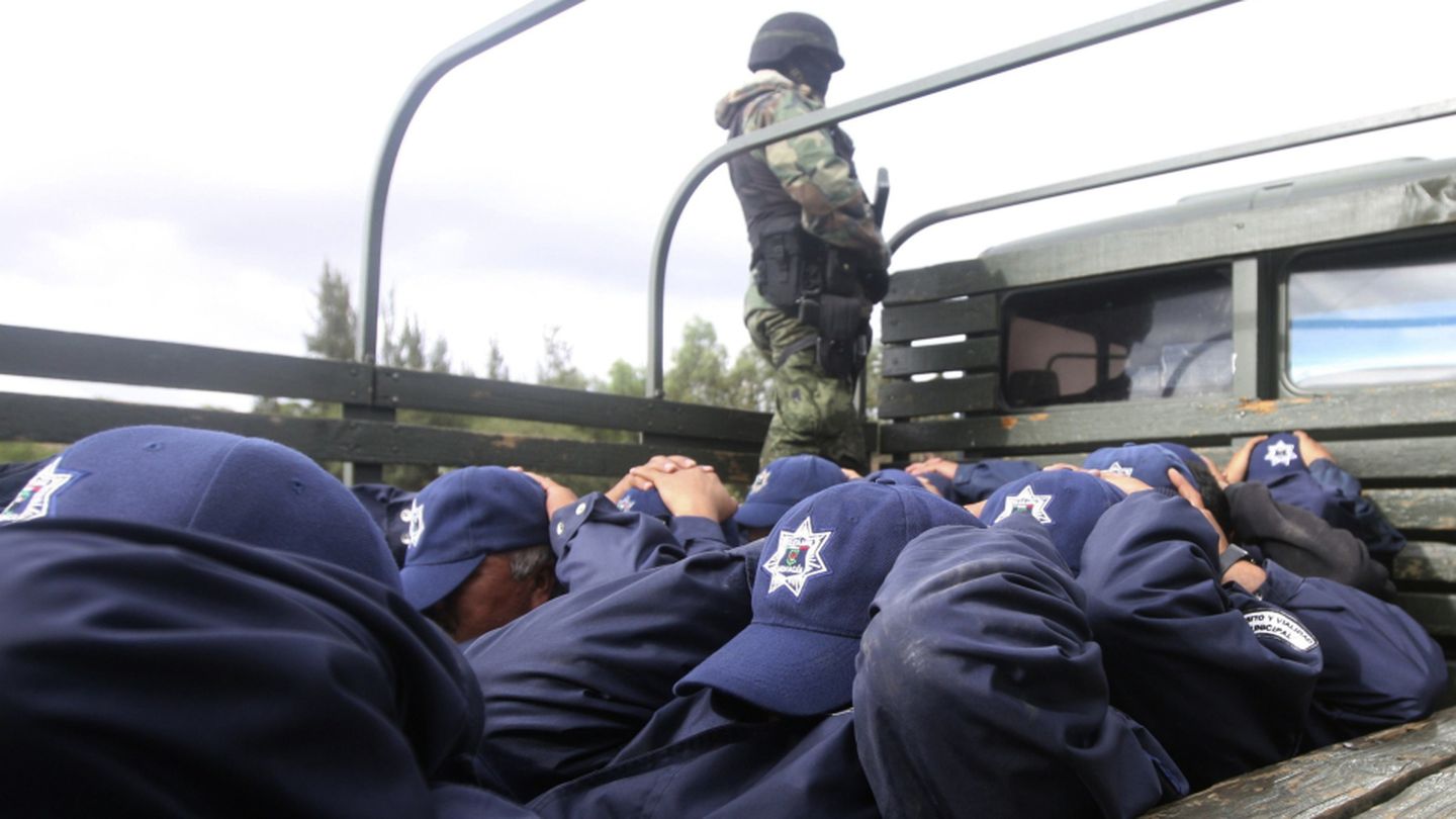 Un soldado custodia a 24 policías arrestados en Tarimbaro (Michoacán) por vínculos con el narcotráfico (Reuters). 