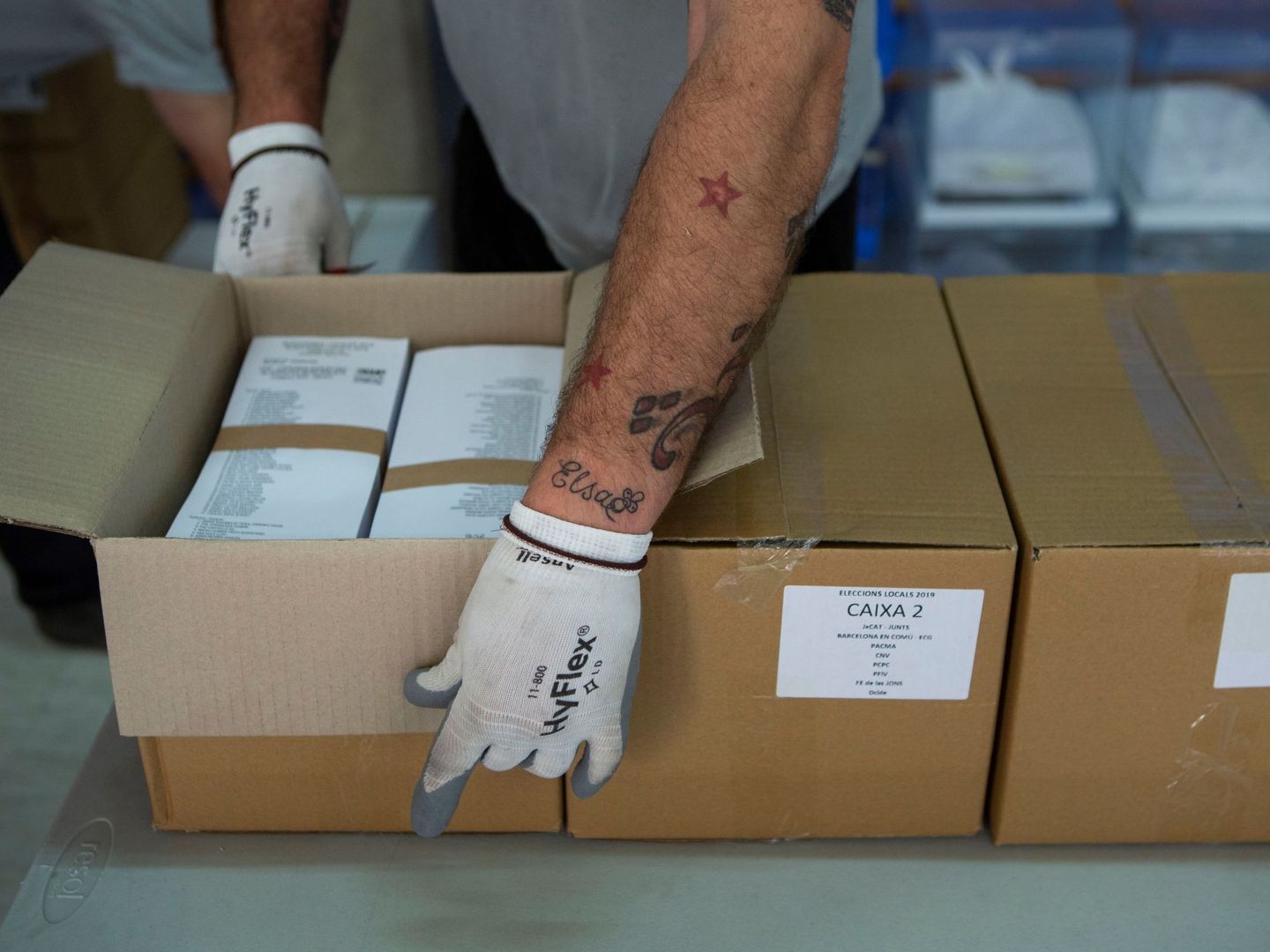 Un operario desempaqueta cajas con papeletas electorales en el almacén municipal de Barcelona. (EFE)